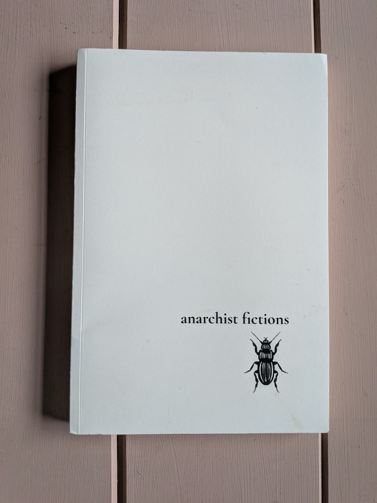 Image of a book against a pink wooden background.
Black text on white: anarchist fictions.
Graphic: a cockroach